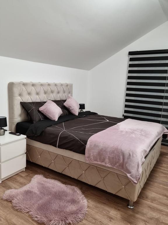 1 dormitorio con 1 cama grande con almohadas rosas en Lilien apartment Airport en Ledine