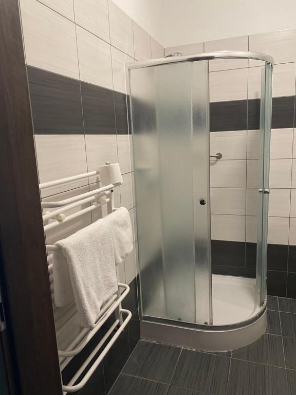 a glass shower in a bathroom with towels at Hotel Kos in Kosobudz