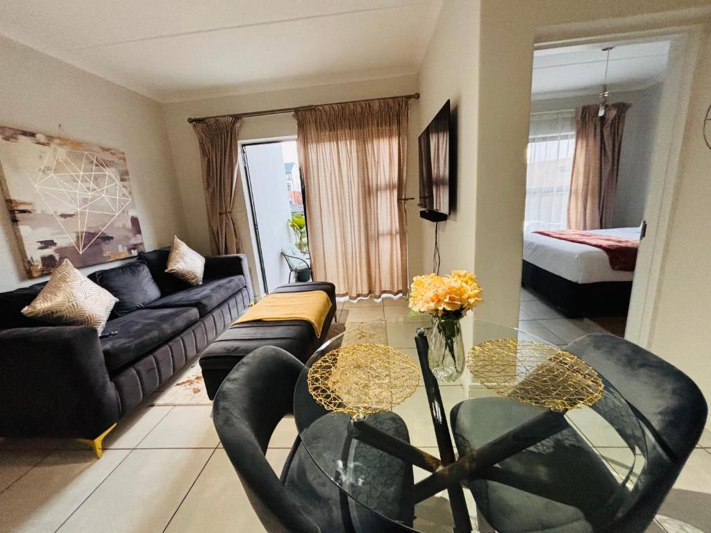 a living room with a glass table and a couch at The Blyde Luxury Retreat in Pretoria