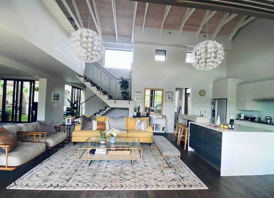 a living room with a couch and a table at Lakeside home in security estate with solar power in Cape Town