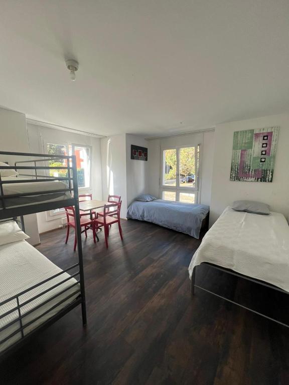ein Schlafzimmer mit Etagenbetten sowie einem Tisch und Stühlen in der Unterkunft Basel-Stadt Gundeldingen Zimmer 404, in Basel