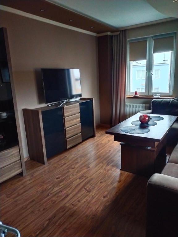 a living room with a couch and a table and a television at Apartament w centrum in Kętrzyn