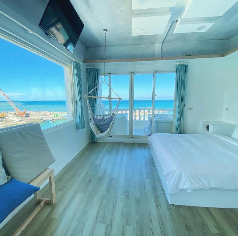a bedroom with a bed and a view of the ocean at Whitelance B&B in Manzhou