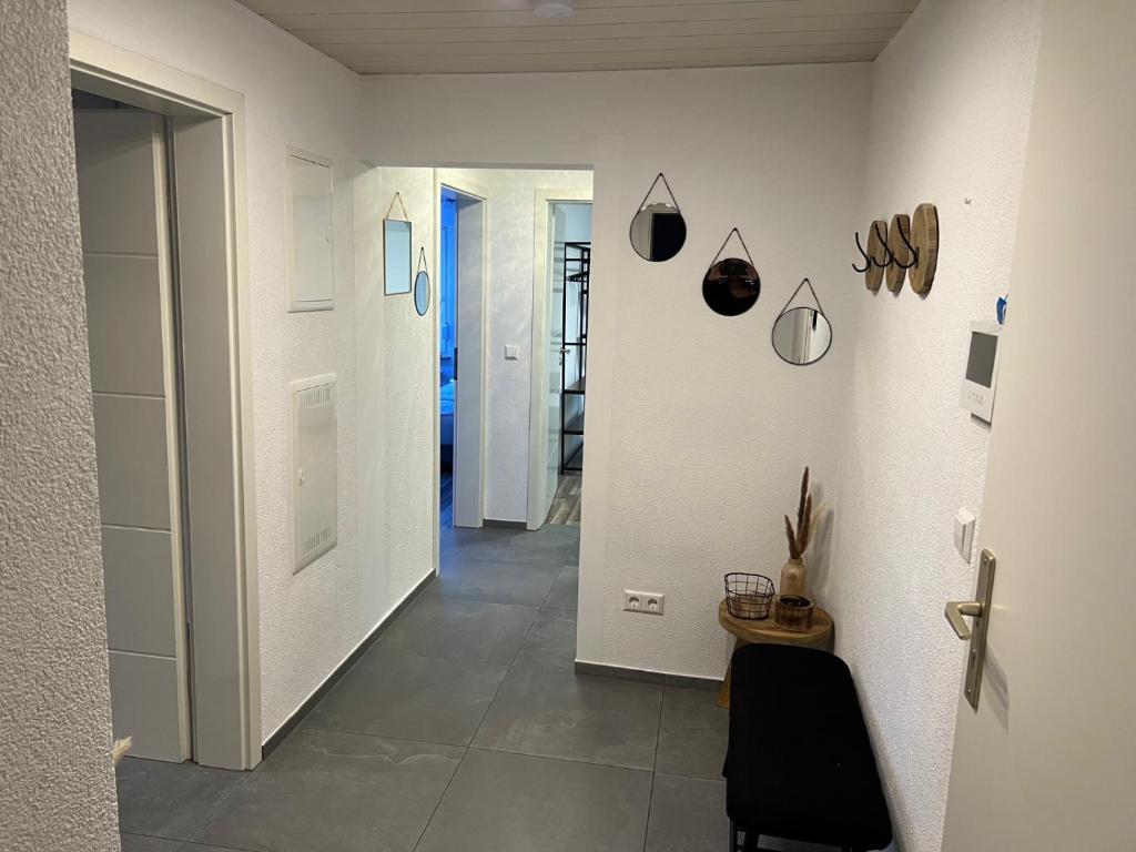 a hallway with white walls and a black chair at DEA Ferienwohnung in Korb