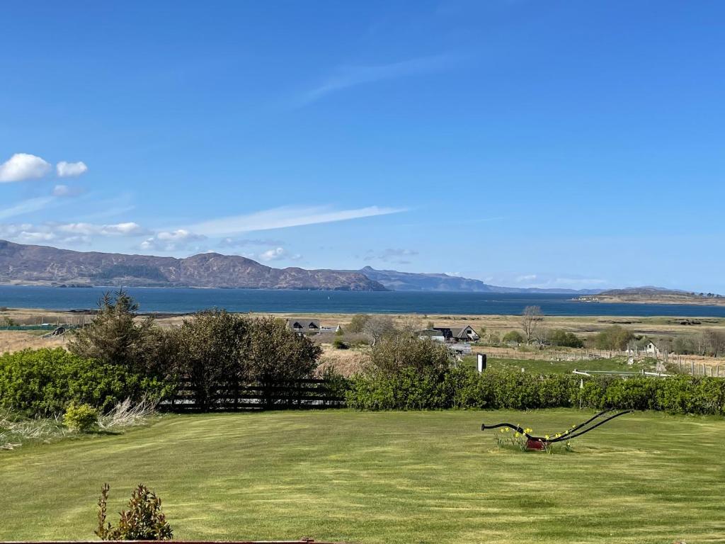 a green field with a view of the water at Ruisgarry Accommodation in Breakish
