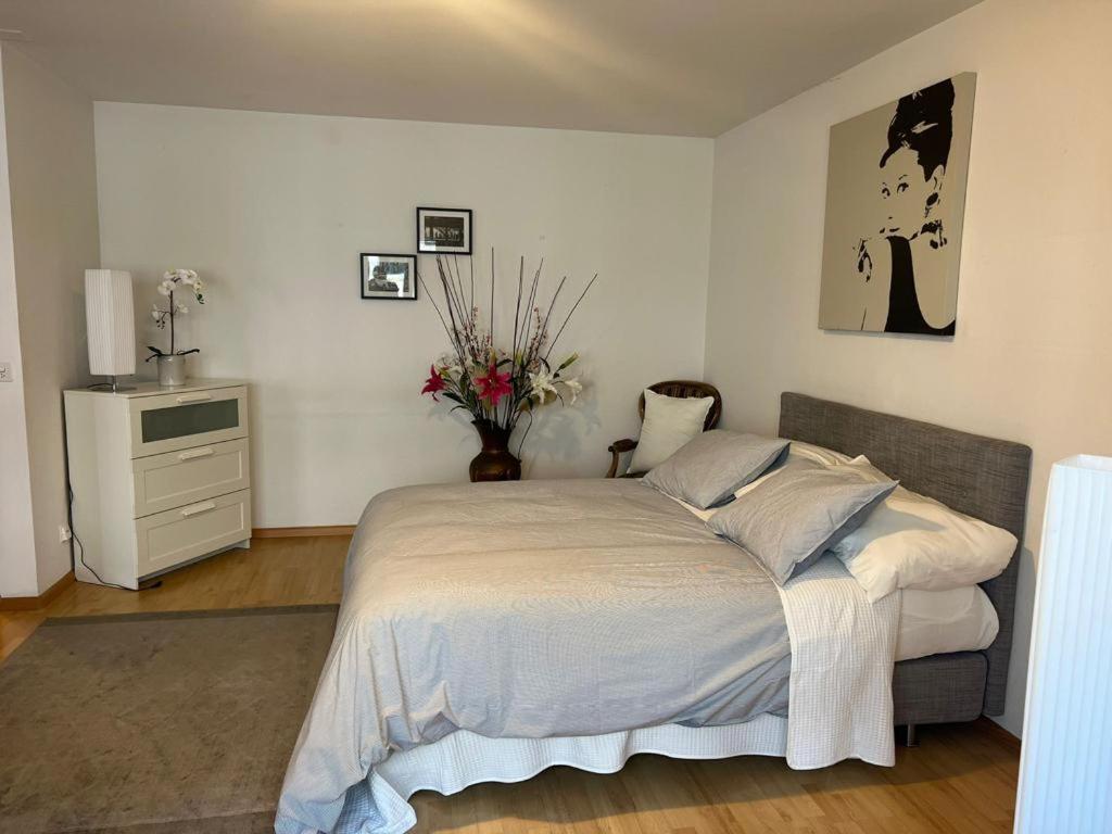 a bedroom with a bed and a vase of flowers at Schweiz (302) in Basel