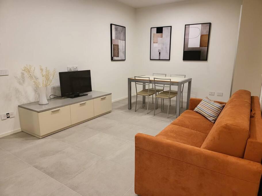 ein Wohnzimmer mit einem Sofa, einem TV und einem Tisch in der Unterkunft Appartamento Centro storico - Massa in Massa