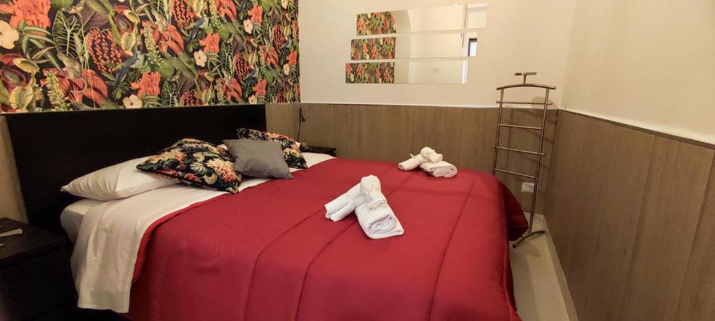 ein Schlafzimmer mit einem roten Bett mit einem Kreuz darauf in der Unterkunft Napuletanata in Neapel