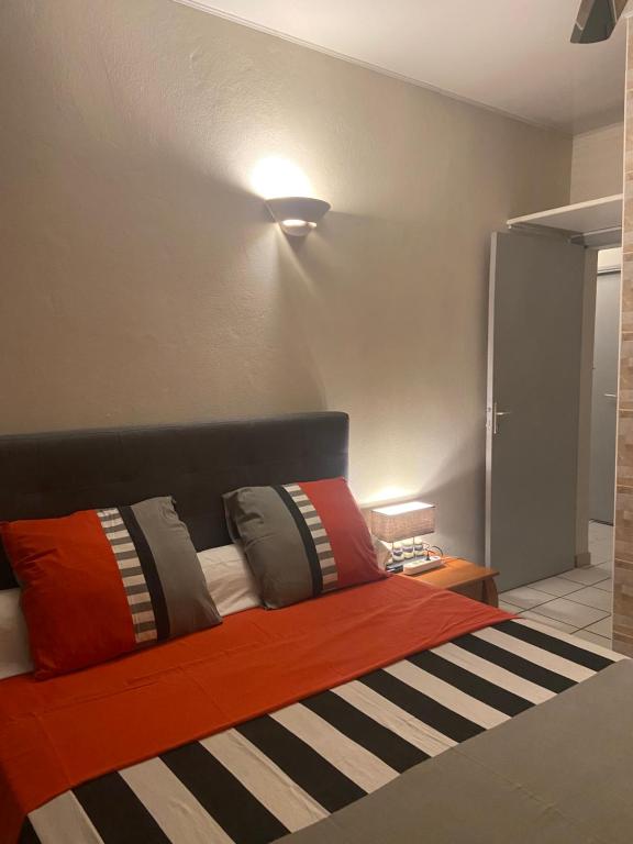 ein Schlafzimmer mit einem Bett mit bunten Kissen darauf in der Unterkunft Happyhome in Saint-Pierre