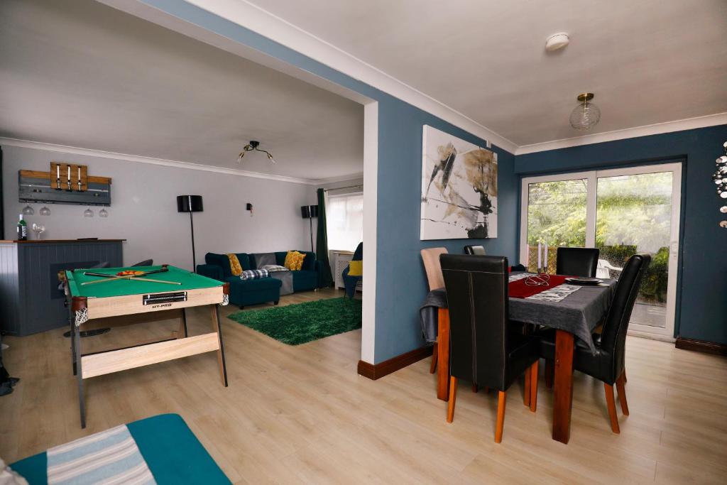 a living room with a ping pong table and a living room with blue walls at Harmony Haven Executive Suite in Nottingham