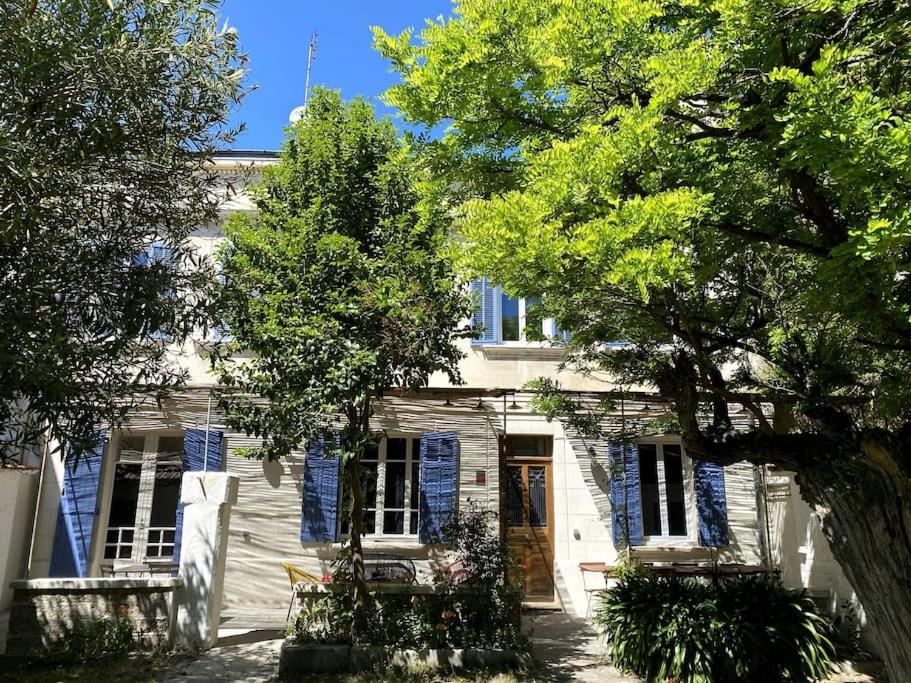 a white house with blue shuttered windows and a door at Maison de caractère avec jardin arboré en Avignon in Avignon