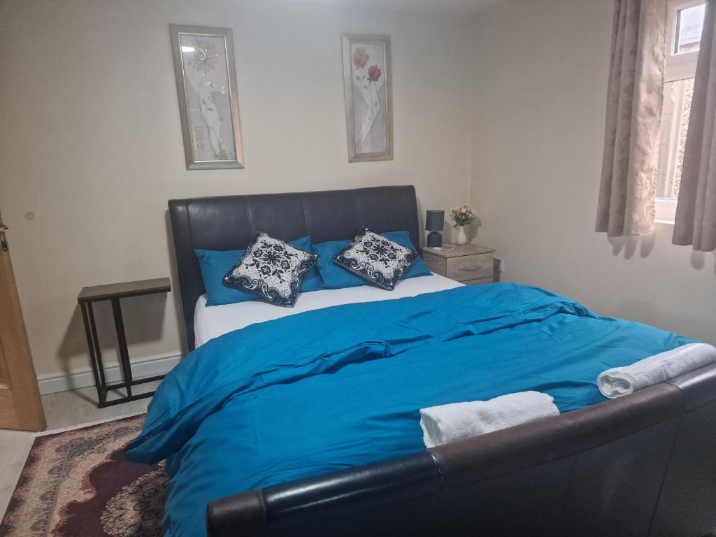1 dormitorio con 1 cama con sábanas y almohadas azules en Perfect for exploring Birmingham en Birmingham