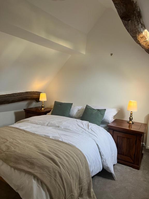 ストウ・オン・ザ・ウォルドにあるCosy Cotswold Cottageのベッドルーム1室(ベッド1台、ナイトスタンド2台、ランプ2つ付)