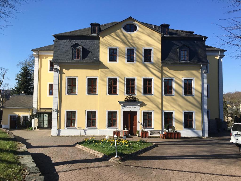 a large yellow building with a black roof at Schnorr-Villa in Schneeberg