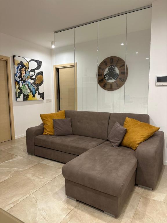 un divano in soggiorno con un orologio sul muro di VIA DIAZ - Nel Centro di Lioni a Lioni