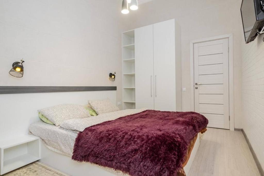um quarto com uma cama com um cobertor roxo em Central Accommodation em Chisinau