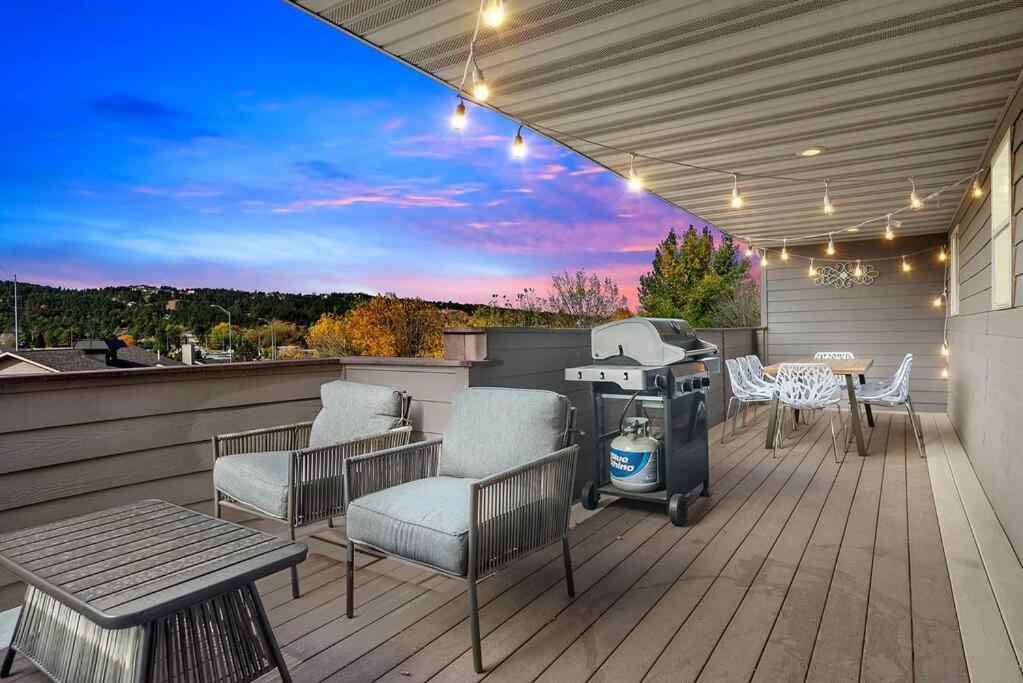 a grill on a deck with chairs and a table at Modern Home-Garage-Scenic Patio in Rapid City