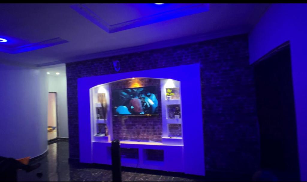 una habitación púrpura con una vitrina con gente en ella en Cozy Home, en Akure