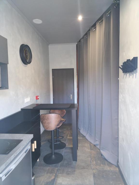 a kitchen with a black table and a stool at Le nid douillet 