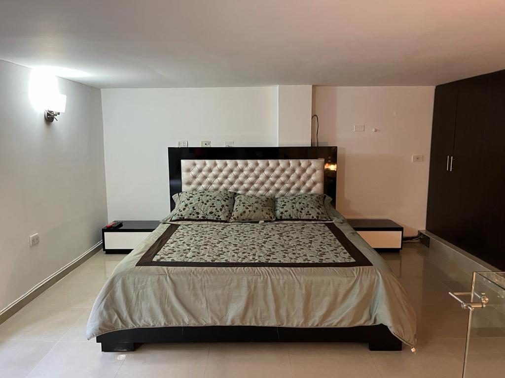 ein Schlafzimmer mit einem großen Bett in einem Zimmer in der Unterkunft Hermoso apartamento ubicado en uno de los mejores sectores de la ciudad in Cali