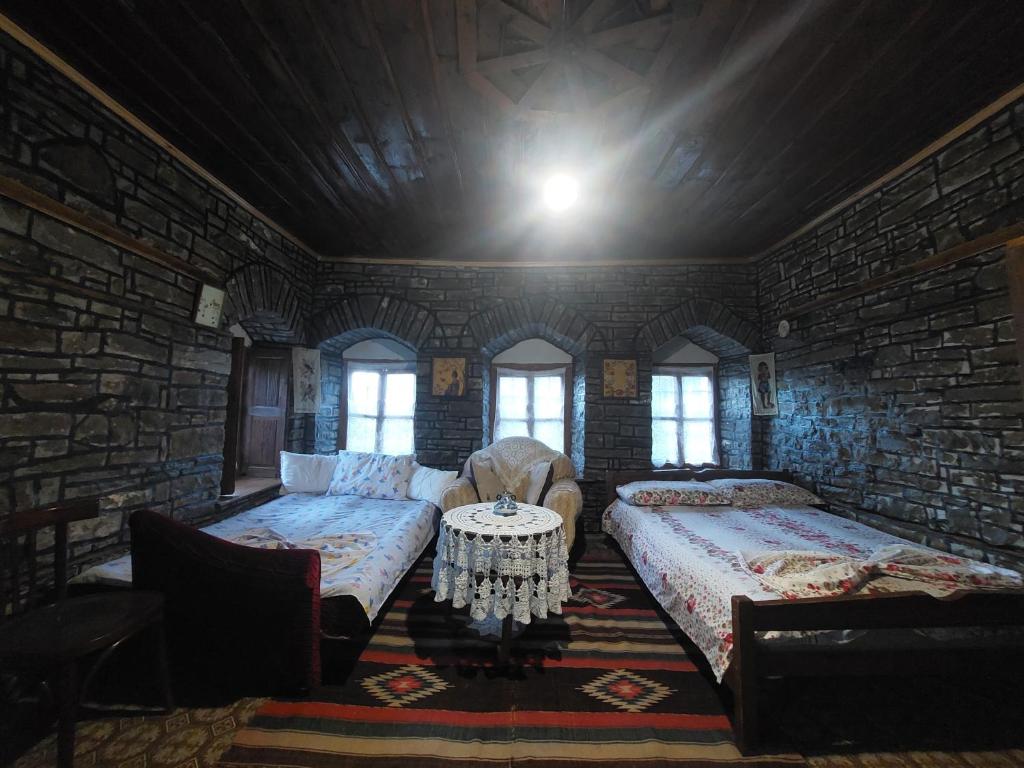 a room with two beds and a couch and a table at guest house in buhal in Përmet