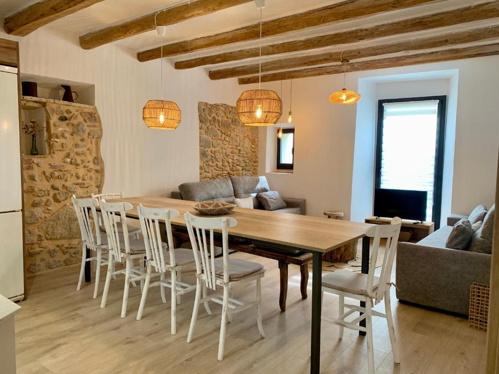 a kitchen and dining room with a wooden table and chairs at Can Joan Empordà in Ordis