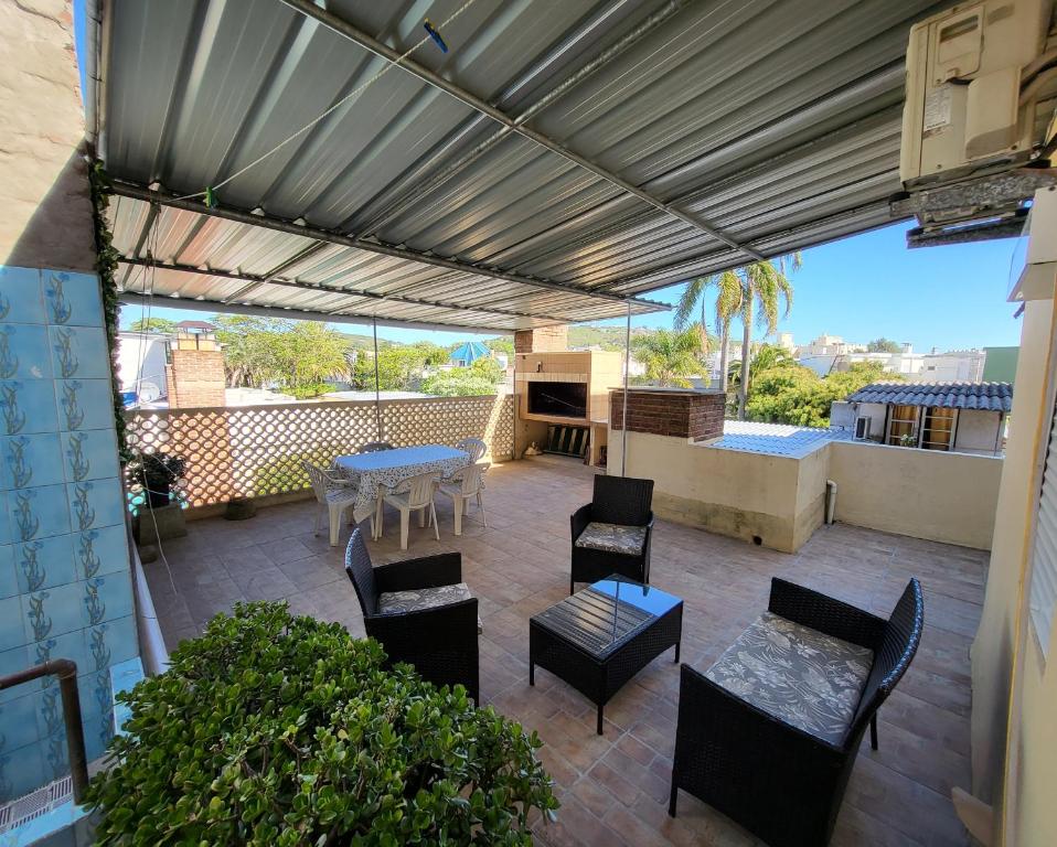 un patio al aire libre con mesa, sillas, mesa y sillón en Apartamento con Terraza y Parrillero, en Piriápolis
