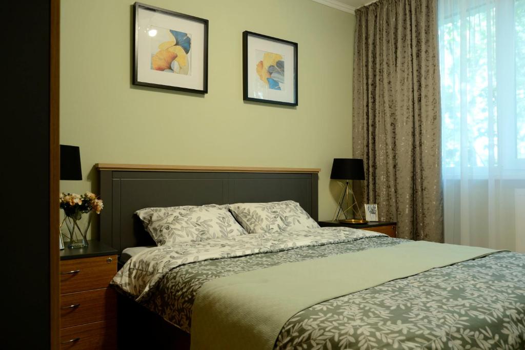 1 dormitorio con 1 cama y 2 cuadros en la pared en Cozy 2 Rooms Apartment Drumul Taberei, en Bucarest