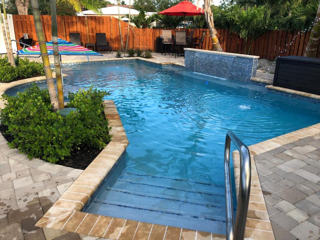 a swimming pool with blue water in a yard at Billy's Resort-Clothing Optional- Men Only - Solo Hombres in Wilton Manors