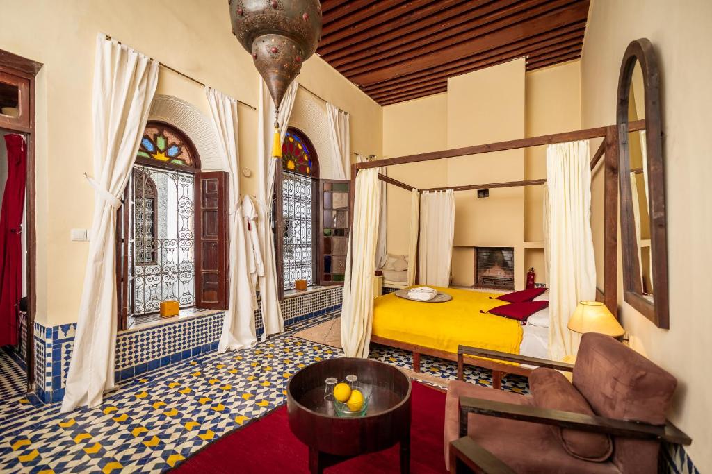 een slaapkamer met een geel bed en een raam bij Riad Tizwa Fes in Fès