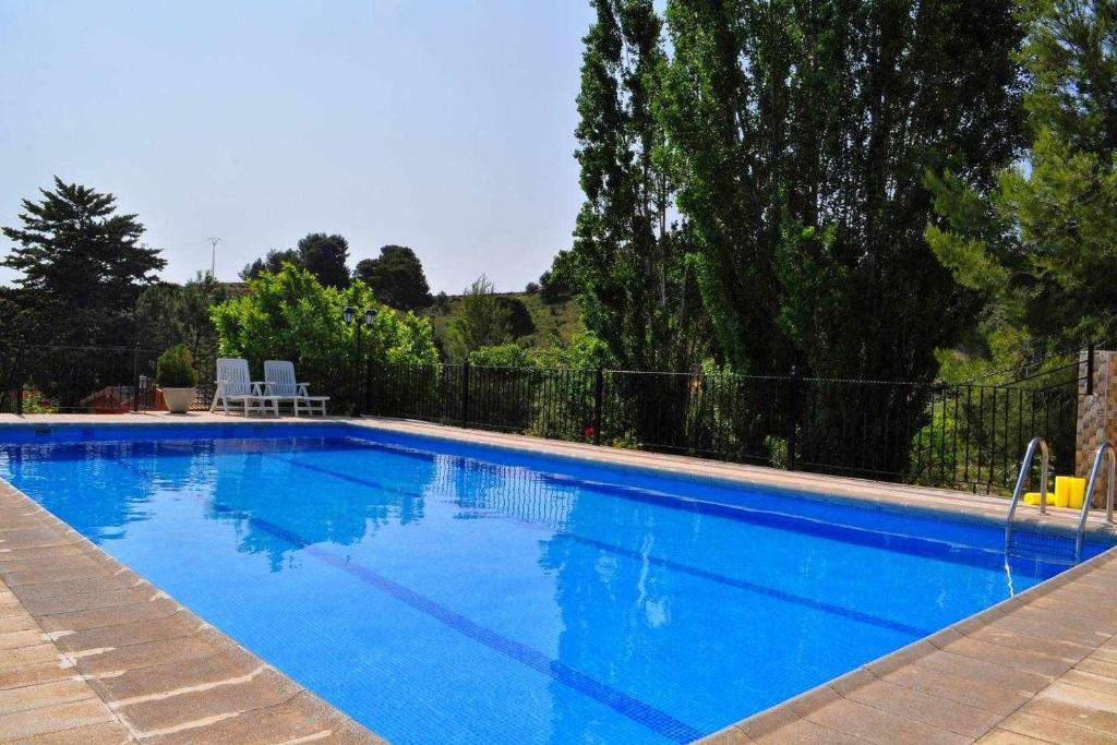 duży błękitny basen na dziedzińcu w obiekcie Casa rural El Salero Piscina campo de fútbol y voley chimenea barbacoa w mieście Moratalla