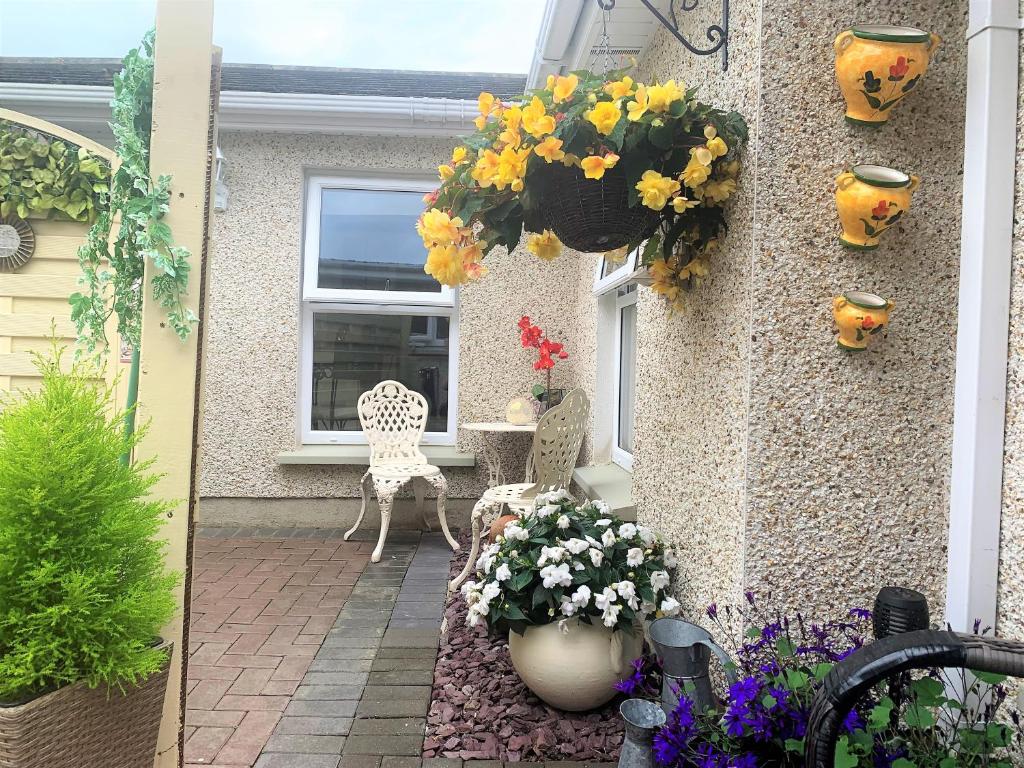 a patio with flowers on the side of a house at Naas 2 Bedroom Back Garden Escape in Naas