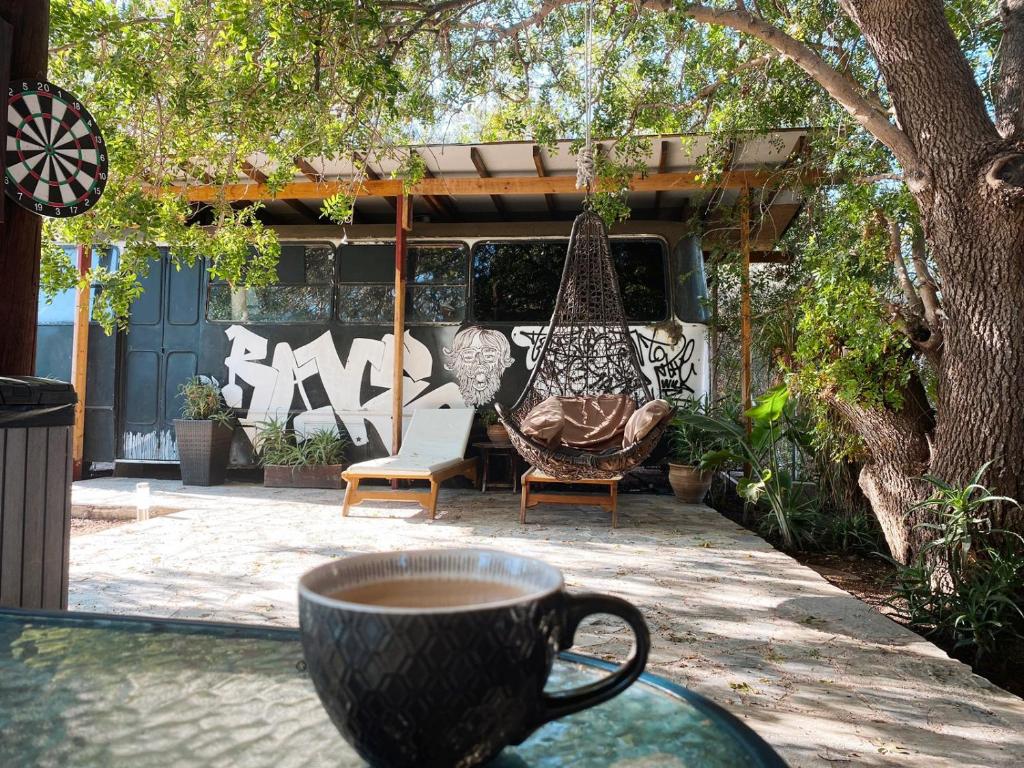 eine Tasse Kaffee auf einem Tisch mit Schaukel in der Unterkunft - Magic Bus - in Klorakas