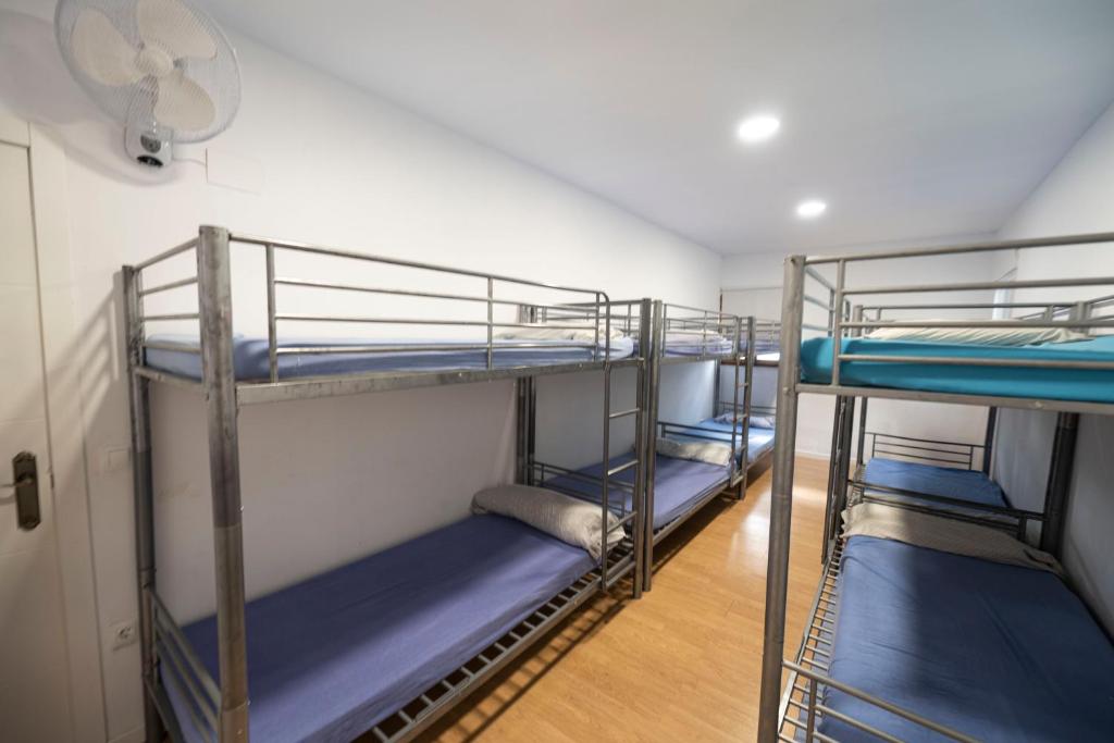 Habitación con 3 literas y sábanas azules. en EL PLA DE ESTIVELLA en Estivella