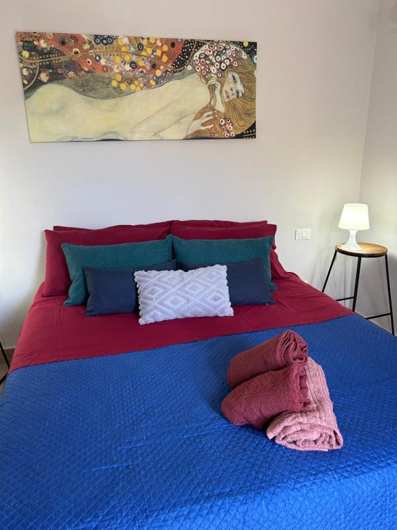 a bed with a blue blanket on top of it at casa vacanze Iside in Termini Imerese