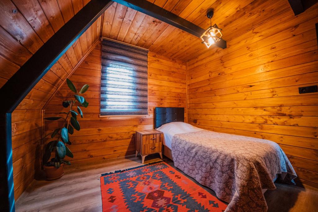um quarto com uma cama num quarto de madeira em Lapis bungalov em Sapanca