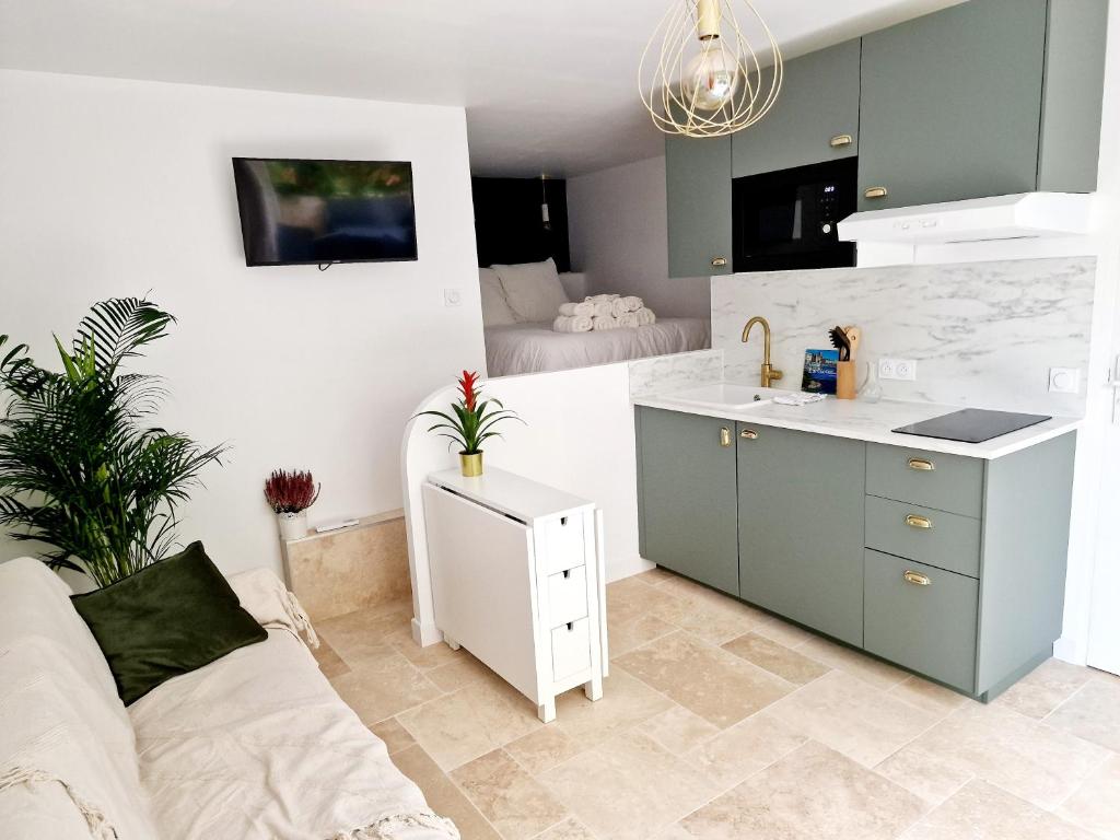 a kitchen with a couch and a sink in a room at Studio Au bas des crêtes en bas de villa à La Ciotat proche de la mer et de Marseille in La Ciotat