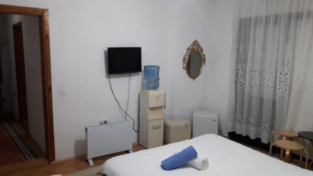 a bedroom with a bed and a tv on the wall at Rooms Struga in Struga