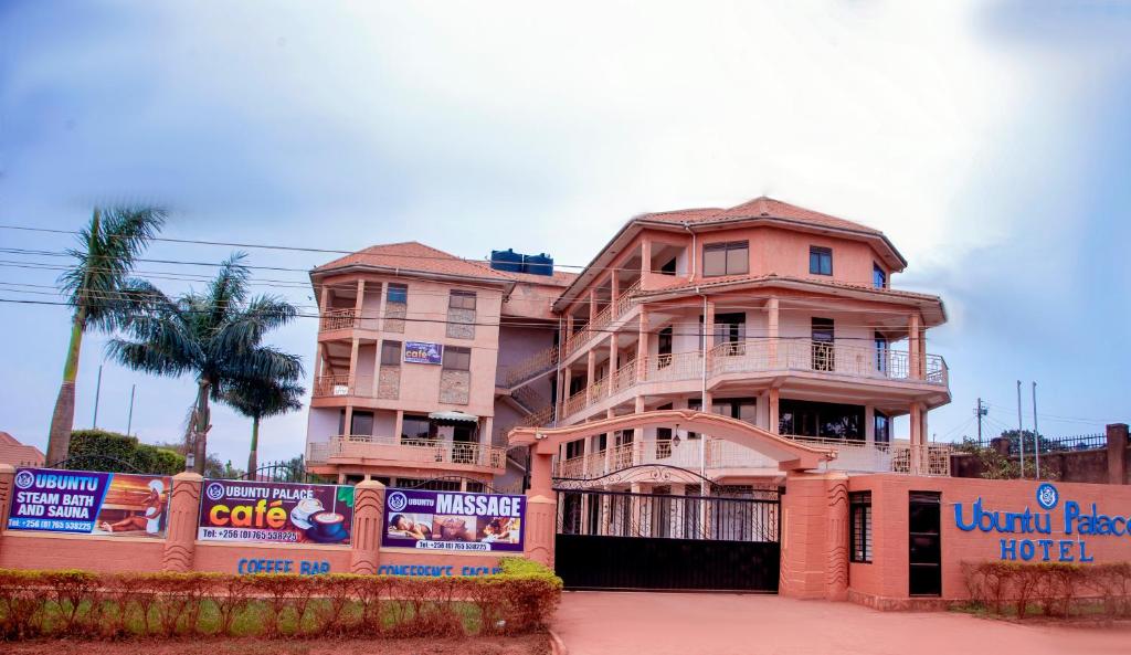 a large pink building with a sign in front of it at Ubuntu Palace Hotel in Kampala