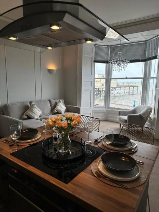 a living room with a table with plates and flowers on it at Swn Y Mor 4 Aberystwyth in Aberystwyth