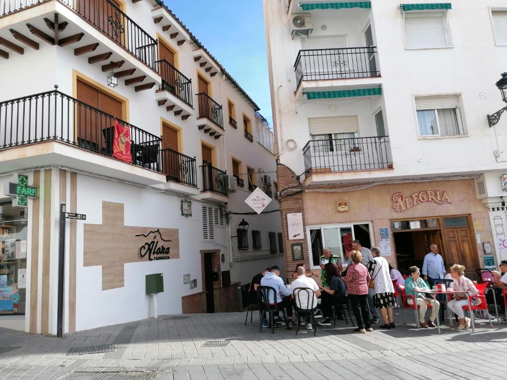 a group of people sitting at tables outside a building at La Casita de Sandra in Alora
