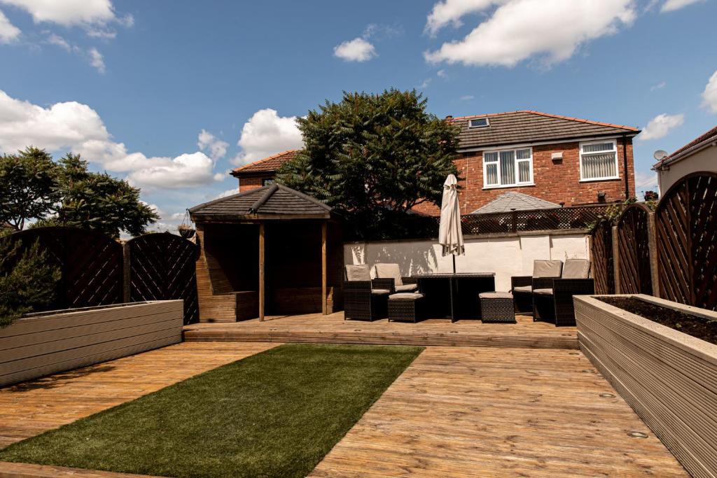 a backyard with a fence and a lawn with an umbrella at Inviting 3-Bed House in Manchester in Manchester