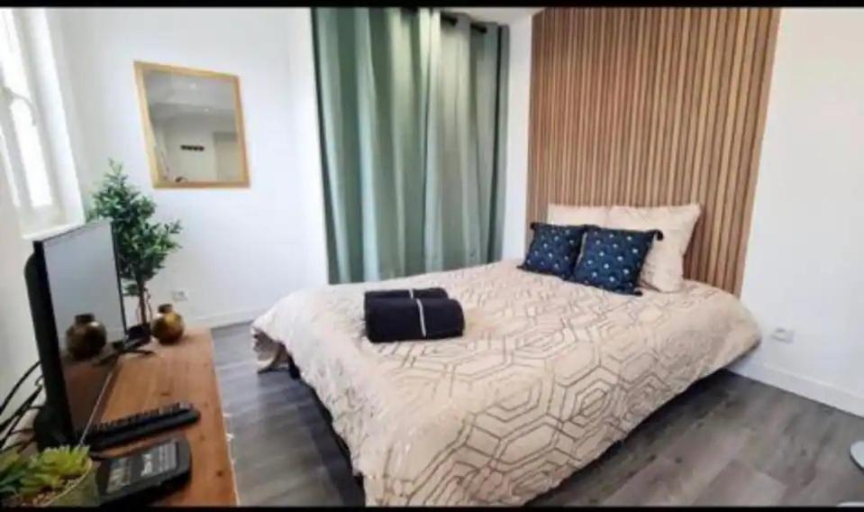 een slaapkamer met een bed, een bureau en een televisie bij Petite maisonnette proche de Giverny in Bonnières-sur-Seine