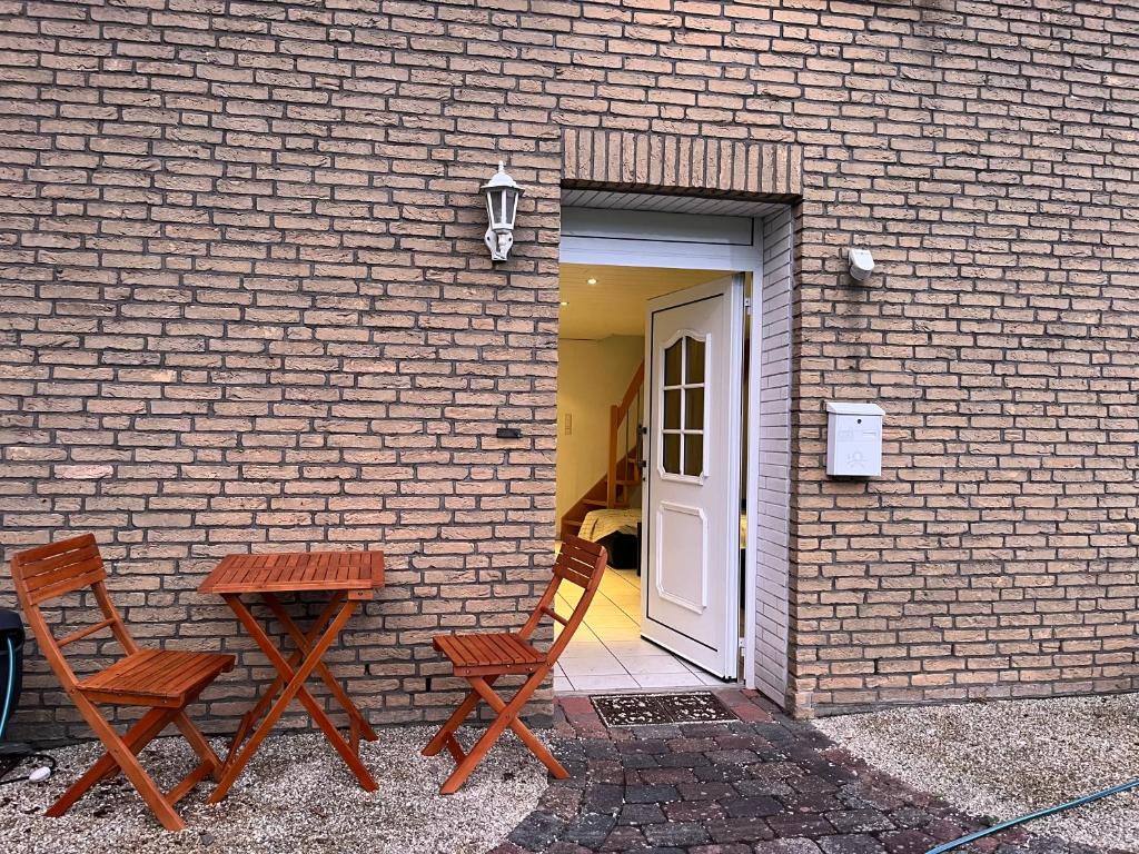 duas cadeiras e uma mesa em frente a um edifício de tijolos em Ferienwohnung auf dem Land und trotzdem stadtnah. em Herford