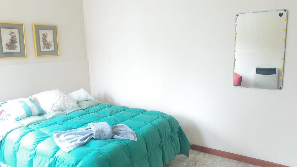 a bedroom with a blue bed with a mirror at Loma del Alto in Alta Gracia