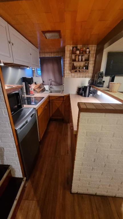 a small kitchen with wooden cabinets and a stove at Logement vue sur la seine in Boulogne-Billancourt