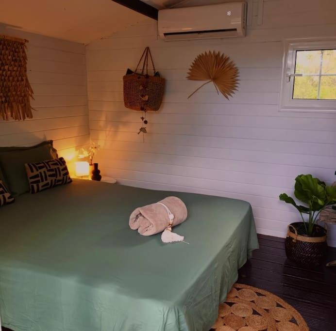 ein Zimmer mit einem Bett und einem Handtuch darauf in der Unterkunft Cabane Charme & Jacuzzi in La Plaine