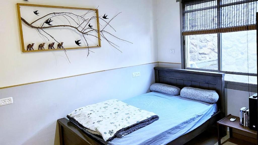 - une chambre avec un lit et une photo sur le mur dans l'établissement אור בתבור, אירוח בכפר תבור., à Kefar Tavor