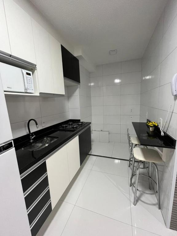 a white kitchen with a sink and a stove at Apartamento Barra Funda - 202 in Sao Paulo