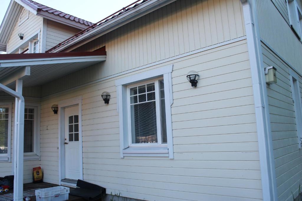 a white house with a window on the side of it at Oulunsalo Apartment in Oulunsalo